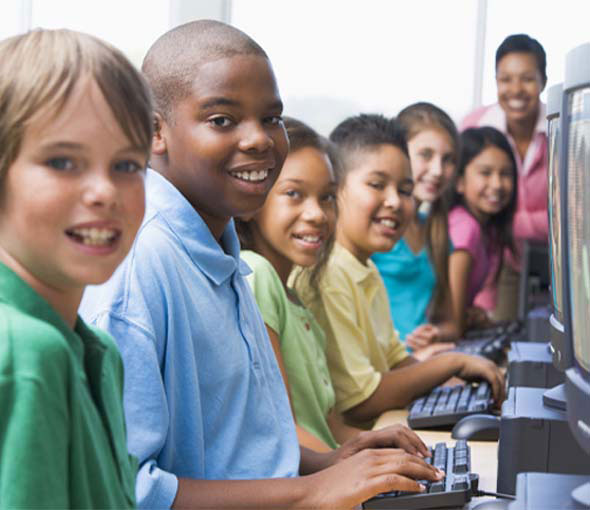 A diverse group of school students learning together in their classroom and smiling in unison