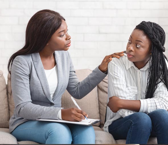 A speech therapist works with a girl at her special education high school